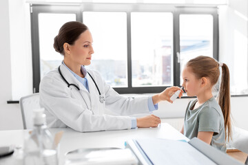 Sticker - medicine, healthcare and pediatry concept - female doctor or pediatrician and little girl patient blowing her nose on medical exam at clinic