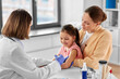 © Syda Productions - medicine, healthcare and pediatry concept - female doctor or pediatrician with syringe making vaccine injection to little girl patient at clinic