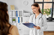 © Syda Productions - medicine, healthcare and people concept - female doctor with clipboard talking to smiling woman patient at hospital