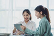 © Kritdanai - Smiling young Asian businesswomen talking to colleague and exchanging ideas together at office.