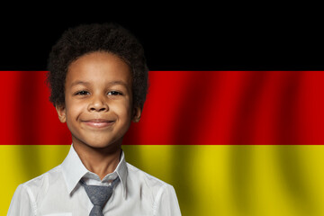 Wall Mural - German kid boy on flag of Germany background. Education and childhood concept