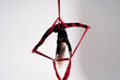 Flexible circus Artist performs on the aerial silk on white background. Concept of willpower, motivation and passion