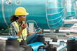 Professional engineer black women working checking and maintenance pipeline construction top of the building. Worker in safety uniform using tablet at pipeline construction system