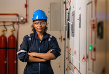 Professional Engineer Black Women Working With Tablet At Warehouse Factory. Engineer Worker Wearing Safety Uniform And Hard Hat. Female  Checking At Electrical Cabinet Control.