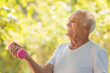 © carballo - senior man doing sport or exercise outdoors with dumbbells