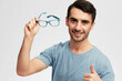 © SHOTPRIME STUDIO - handsome man in blue t-shirt glasses gesture hands smile emotions light background