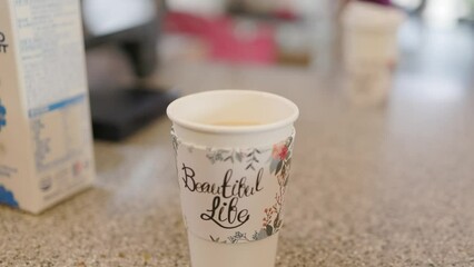 Wall Mural - Closeup of a cup of coffee on a table in a cafe