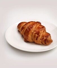 Canvas Print - Vertical shot of a French buttery croissant on a plate on a white background