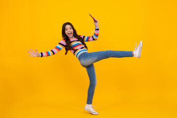 Poster - Amazed teenager. Teenage girl with smart phone. Portrait of teen child using mobile phone, cell web app. Excited teen girl.