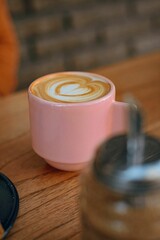 Sticker - Vertical shot of a cup of latte coffee on a wooden table