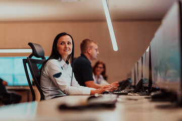 Wall Mural - Female security operator working in a data system control room offices Technical Operator Working at workstation with multiple displays, security guard working on multiple monitors