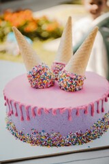 Sticker - Pink and purple drip cake with waffle cones with sprinkles on it - vertical shot