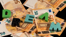 Message "dream" In Colorful Wooden Letters, On A Pile Of Fifty Euro Notes. European Currency.