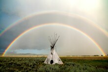 White Conical Tent Resembling A Tipi Against The Rainbow Background