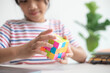 © FAMILY STOCK - NAKHON RATCHASIMA, THAILAND - JULY 14, 2022:Asian little cute girl holding Rubik's cube in her hands. Rubik's cube is a game that increases the intelligence of children.