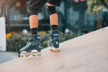 Close-up of the legs of a roller skater performing tricks and just riding on the ramp in urban sports park. Teenage hobby concept