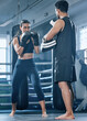 Boxing woman training in gym with trainer for better fitness, wellness and health. Active and young female client doing punching and kickboxing workout or exercise with personal coach in sportswear