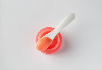 Canvas Print - Cosmetic products swatch. Creamy pink texture smear into the spoon on the jar on white background.