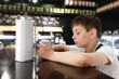 © Arkady Chubykin - Child playing with smartphone at bar