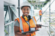 © Allistair/peopleimages.com - Portrait of proud black construction worker leading with power while managing site logistics on tablet. Happy female engineer supervising a building project and inspection of architectural details