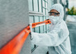 © N Felix/peopleimages.com - Covid healthcare worker responding to a biohazard in a public area using barrier tape outside. First responder in protection hazmat suit and mask separating a space due to a new pandemic or outbreak