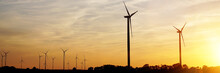 Beautiful Sunset Above The Windmills On The Field. Renewable Energy Sources Concept