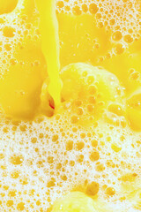 Wall Mural - Closeup of splashing orange juice, top view. Splash of fresh sweet orange, mango, fruit juice. Freeze motion of pouring orange juice .