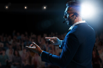 motivational speaker with headset performing on stage