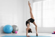 © New Africa - Cute little girl doing gymnastic exercise indoors