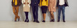 © Studio Romantic - People in smart casual clothes by office wall. Row of company employees in pants, skirts, jackets and jumpers of brown, yellow, dark blue, beige color. Low section legs. Work dress code concept header