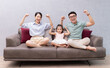 © Timeimage - Young Asian family sitting on sofa