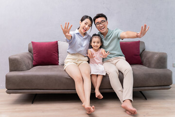 Canvas Print - Young Asian family sitting on sofa