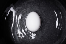Single White Egg In A Water On A Black Background. Top View. 