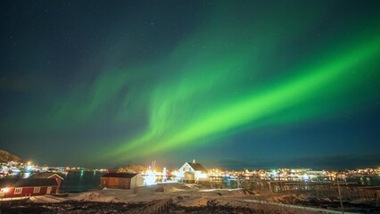 Wall Mural - beautiful aurora borealis, northern lights over illuminated fishing village on arctic ocean coastlin