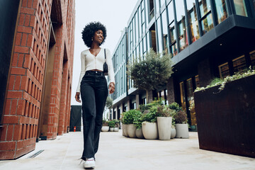 Wall Mural - Portrait of attractive young woman walking outside in the city