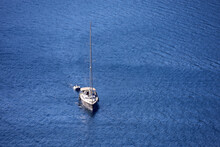 Aerial View To Yacht With The Sails Lowered On Blue Sea Surface. Background For Traveling And Vacation