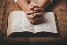 Close Up Of Christian Woman Hand On Holy Bible Are Pray And Worship For Thank God In Church With Black Background, Concept For Faith, Spirituality And Religion