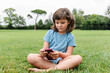 © ADDICTIVE STOCK - Girl using smartphone on park lawn