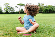 © ADDICTIVE STOCK - Happy girl sitting on lawn and dancing