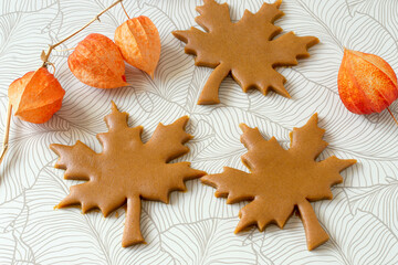 cutting out autumn gingerbread in shape of maple leaf