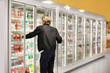 © lado2016 - Man choosing frozen food from a supermarket freezer	, reading product information