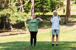 © LIGHTFIELD STUDIOS - full length of cheerful senior couple in sportswear exercising with sports equipment in green park.