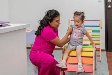 Pediatric doctor plays with a girl in the playground of her medical office