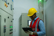 © visoot - Engineer checking the electrical system with panel in control or server room.