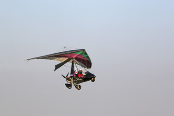 Poster - Ultralight airplane flying in a blue sky	