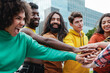 © Vane Nunes - Young diverse group of people stacking hands together outdoor - Diversity team concept