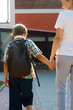 © Elroi - Back to school. Mom takes her son to school on the first of September. The parent holds the child's hand on the way to the educational institution. Boy with a backpack, back view