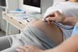 © New Africa - Doctor examining pregnant woman in hospital, closeup