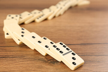 Wall Mural - Fallen white domino tiles on wooden table