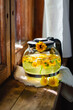 Calendula tea in a glass teapot on a wooden windowsill